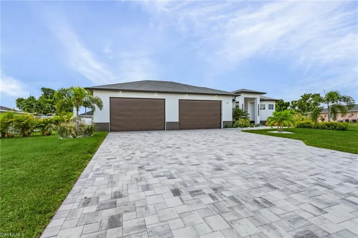 View of front of property with a garage and a front lawn