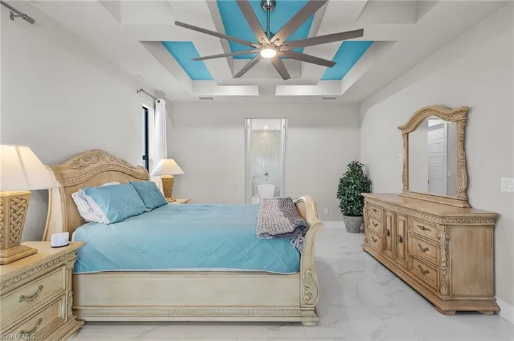 Bedroom with ceiling fan and a raised ceiling