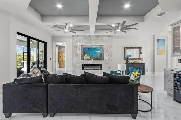 Living room featuring a fireplace, beam ceiling, and coffered ceiling