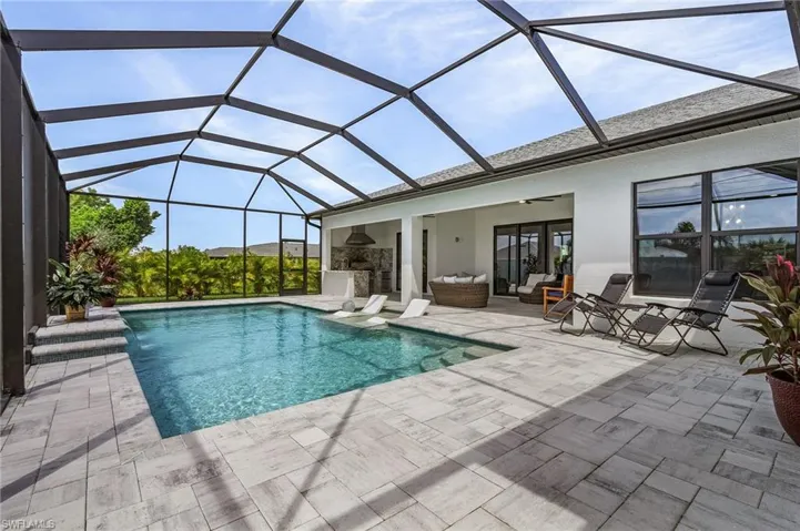 View of pool featuring a lanai, an outdoor hangout area, ceiling fan, and a patio area