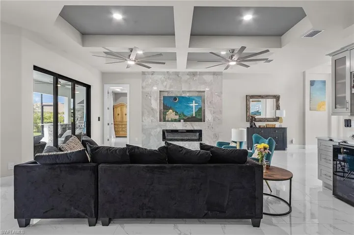Living room with beam ceiling, wine cooler, a premium fireplace, and coffered ceiling