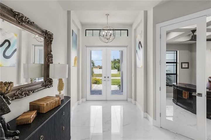 Entrance foyer featuring french doors and a notable chandelier