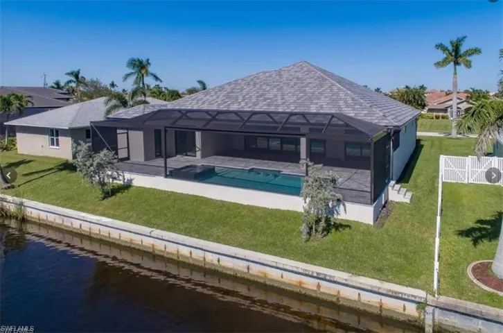 Back of house with a yard, a patio, and a water view