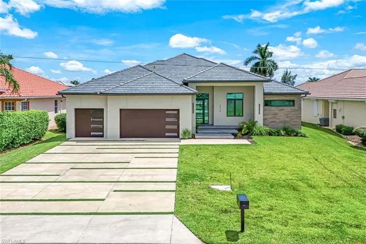 View of front of house featuring a front yard and a garage