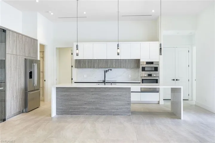 Kitchen with an island with sink, pendant lighting, stainless steel appliances, and sink