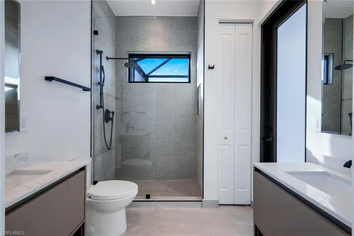 Bathroom featuring vanity, toilet, tile patterned floors, and walk in shower