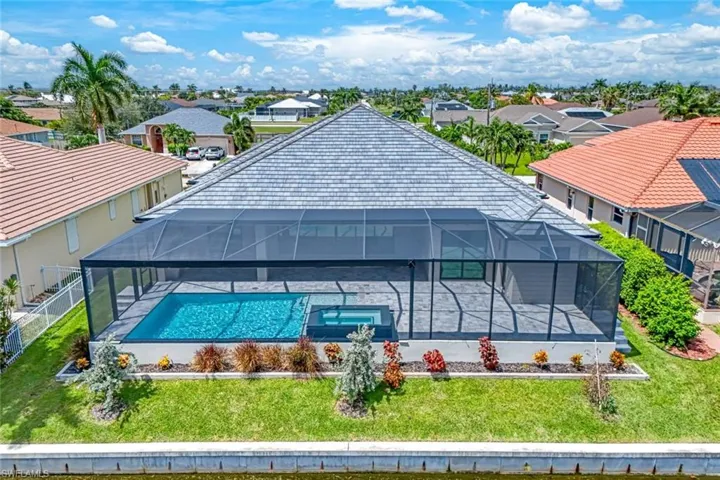 View of swimming pool with a lawn, a patio area, and glass enclosure