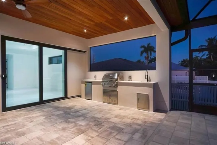Patio at twilight with a grill, area for grilling, and ceiling fan
