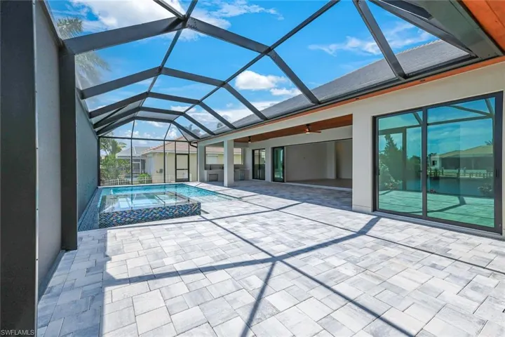 View of pool with a lanai and a patio