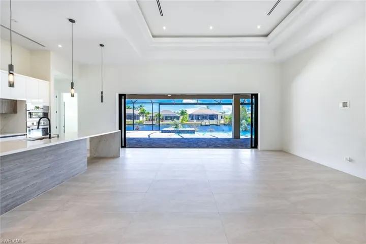 Unfurnished living room with a high ceiling and sink