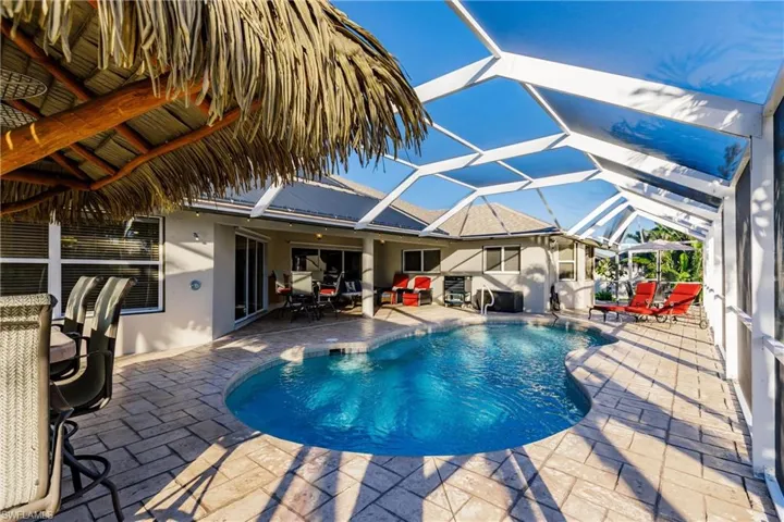 View of pool featuring a patio and glass enclosure