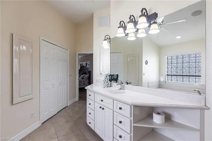 Bathroom with tile patterned flooring, visible vents, baseboards, ceiling fan, and vanity