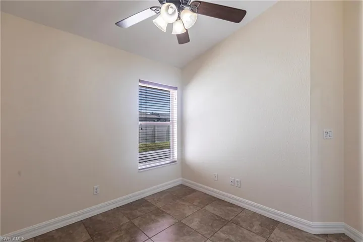 Tiled empty room with baseboards and ceiling fan
