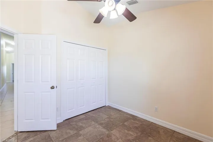 Unfurnished bedroom featuring a closet, visible vents, ceiling fan, and baseboards