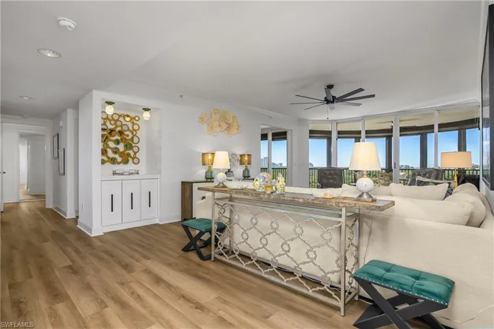 Great Room with wood finished floors, ceiling fan custom built in dry bar with quartz countertop