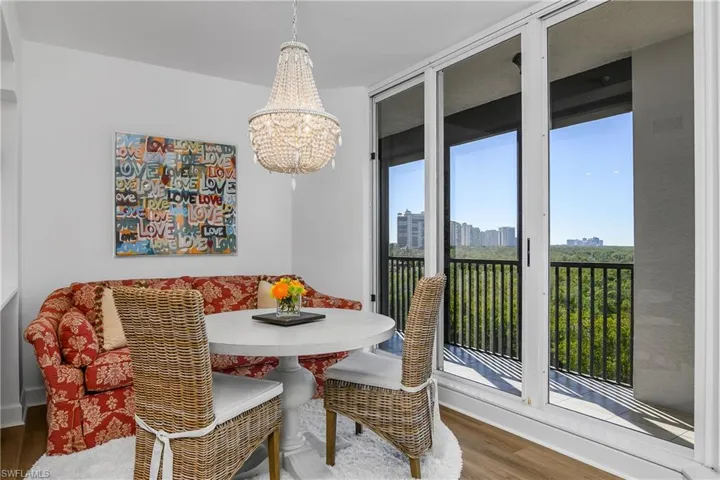 Dining space with wood finished floors, RH chandelier, and a view