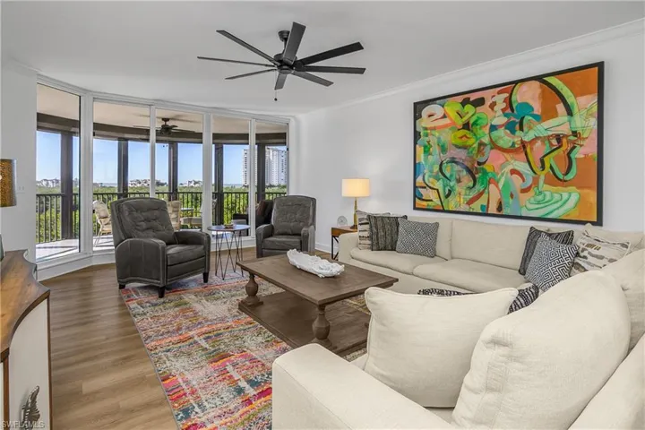 Great room with expansive windows, wood finished floors, crown molding