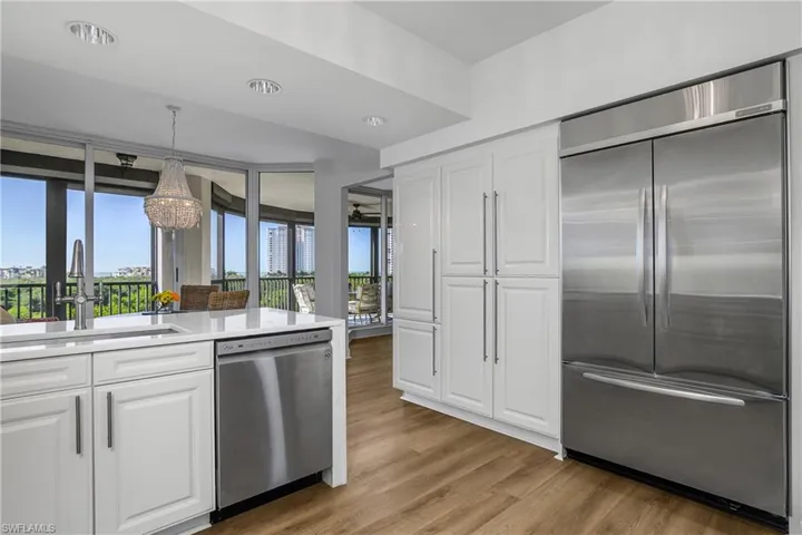 Kitchen featuring appliances with stainless steel finishes, white cabinetry, light wood-type flooring, light quartz counters, and RH light fixtures