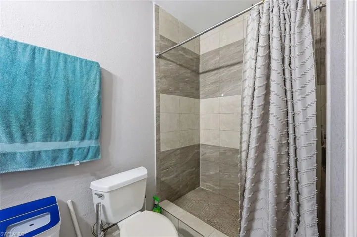 Bathroom with a textured wall and a stall shower