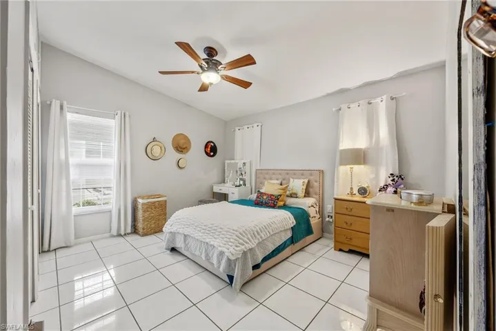 Bedroom featuring ceiling fan, vaulted ceiling, and light tile patterned floors