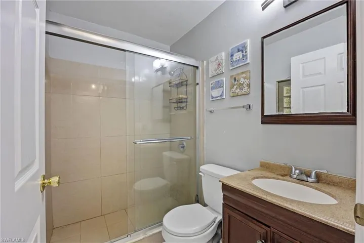Bathroom featuring a shower stall and vanity