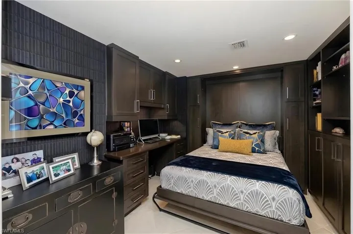 Integrated wall unit with a Murphy bed, built-in desk, and surrounding cabinetry