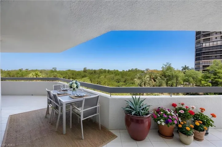 Open-air balcony featuring a tiled floor and a perimeter wall with a dark railing