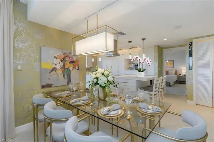 Open-concept dining area with a glass-top table, gold-finished chairs, and a rectangular pendant light fixture