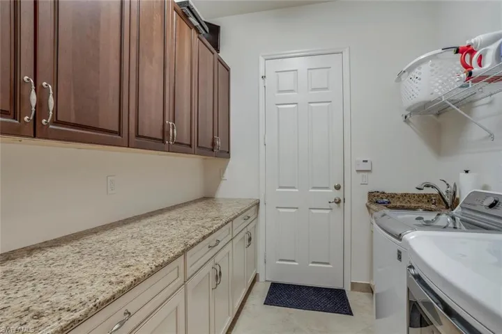 Custom laundry room with laundry sink, cabinets & granite counters