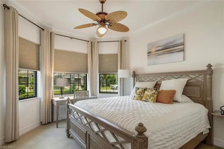 Primary bedroom has a sitting area, coffered ceiling, door to lanai, and two walk-in closetswith custom built-in cabinetry
