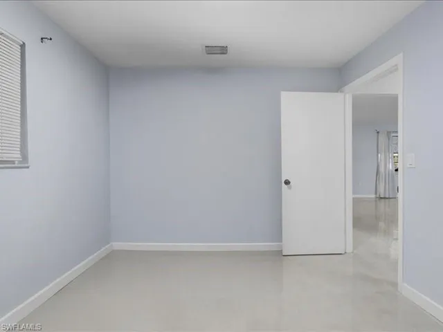 Empty room featuring concrete floors and baseboards