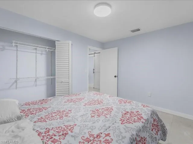 Bedroom with light tile patterned flooring and a closet