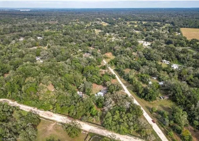 Expansive aerial perspective showcasing a predominantly wooded landscape with scattered residential properties