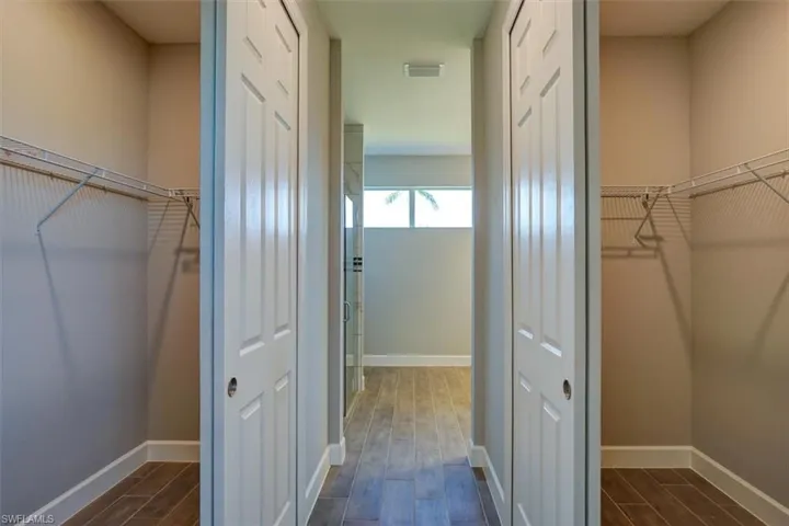 Walk in closet with wood finish floors
