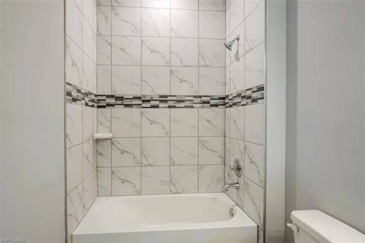Bathroom featuring toilet and shower / bathing tub combination