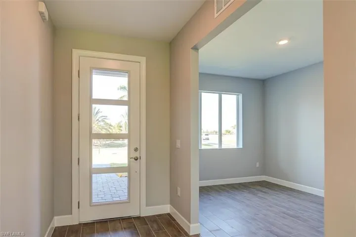 Entryway with dark wood-style floors, visible vents, and baseboards