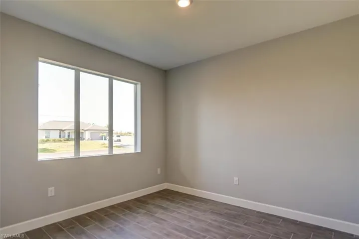 Spare room with baseboards and dark wood finished floors