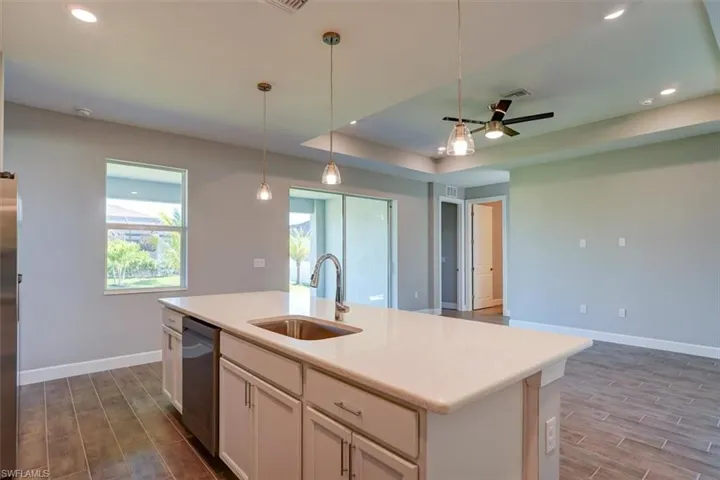 Kitchen featuring light countertops, visible vents, appliances with stainless steel finishes, a sink, and an island with sink