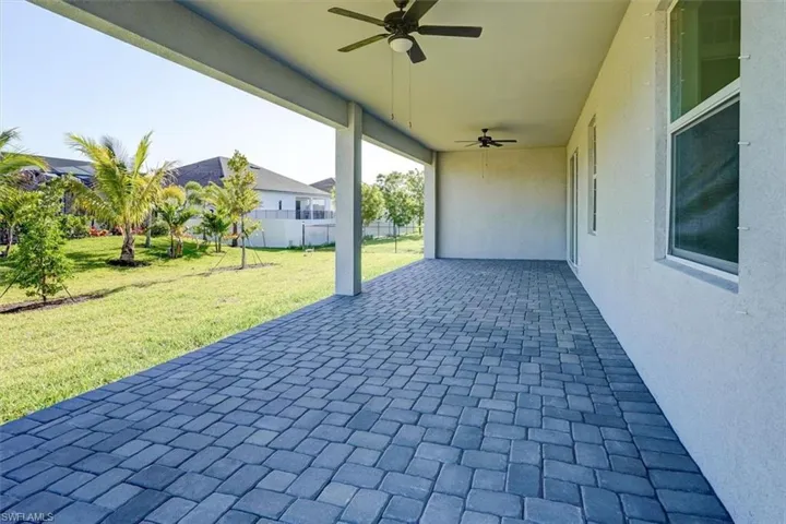 View of patio with fence and a ceiling fan