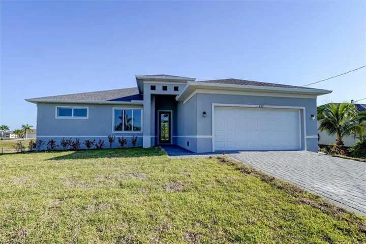 Prairie-style home with a garage, a front lawn, decorative driveway, and stucco siding