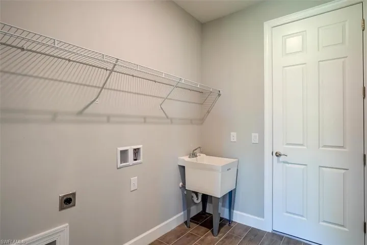 Laundry area featuring hookup for an electric dryer, laundry area, washer hookup, baseboards, and wood tiled floor