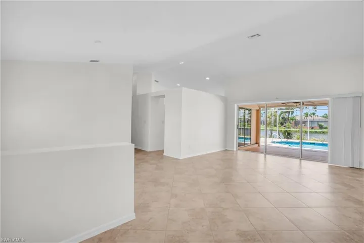 From the entry way, lofted ceiling and light tile floors.  This space can open into kitchen, on the other side of the wall next to sliders.