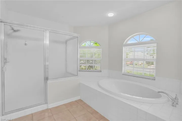 Master Bathroom featuring shower with separate bathtub, tile patterned floors, and a healthy amount of sunlight