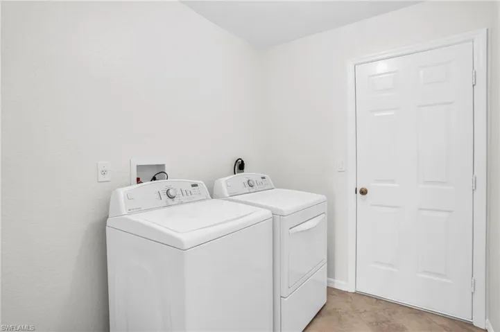Laundry room featuring light tile patterned flooring and separate washer and dryer