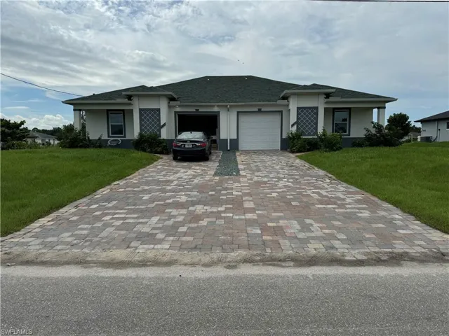 View of front of house with a front lawn and a garage