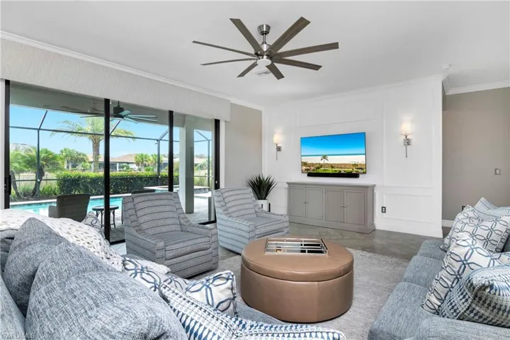 Living room with ceiling fan and crown molding