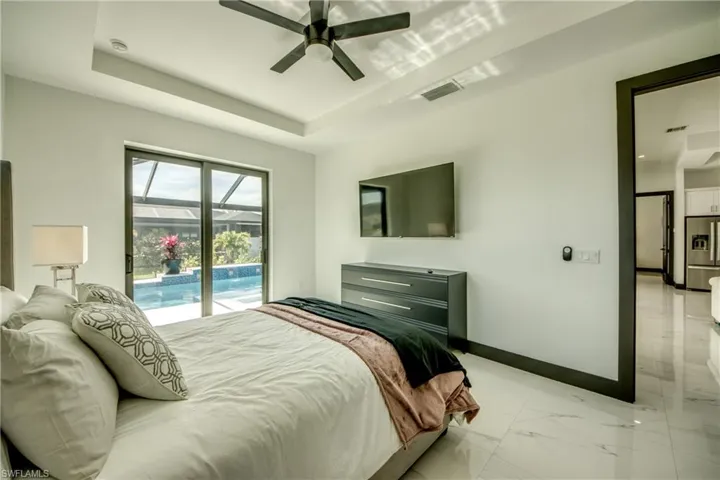 Bedroom - featuring visible vents, vaulted ceilings, walk in closet, with pool vies and exterior access