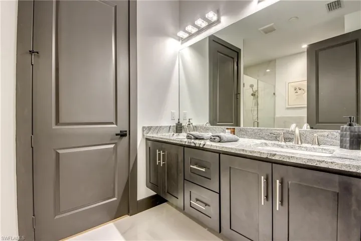 Bathroom with double vanity , marble floor features