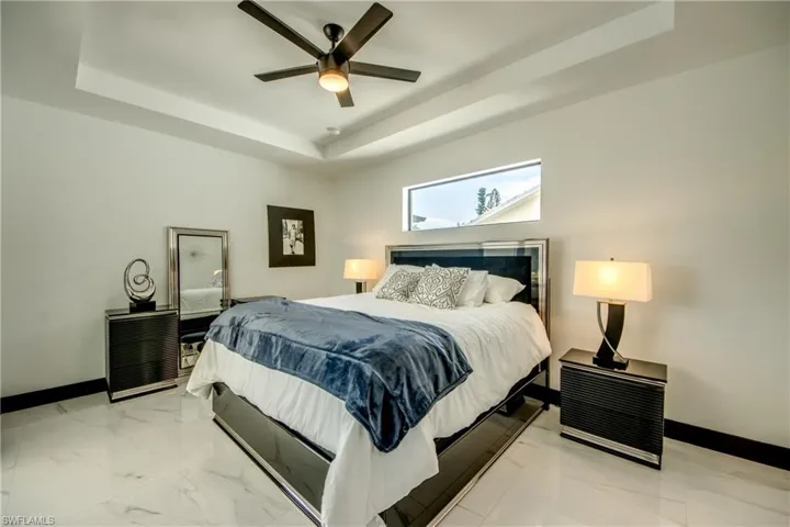 Primary Bedroom, featuring visible vents, raised ceilings, and access to the exterior.