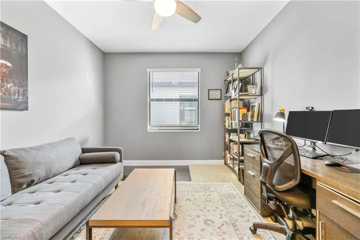 Office featuring light tile patterned floors, baseboards, and ceiling fan